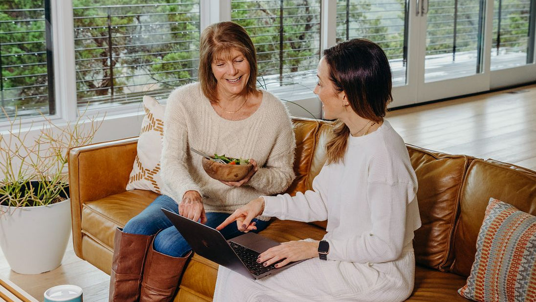 Two women sitting on a couch having lunch and creating a Your Super Build Your Own Bundle 